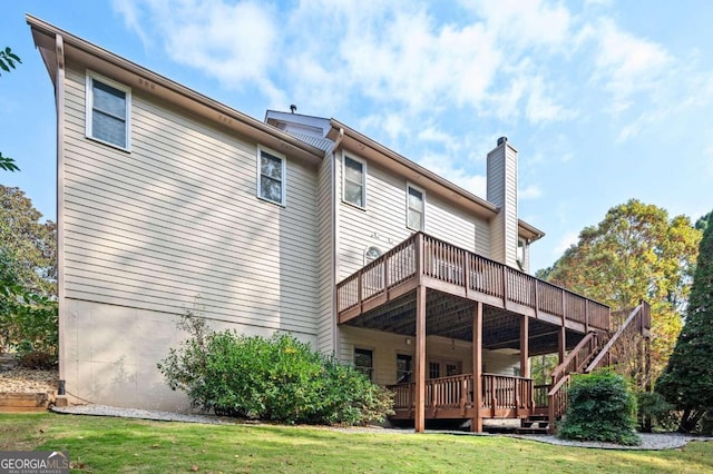 rear view of house with a wooden deck and a lawn