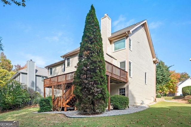 rear view of property with a deck and a yard