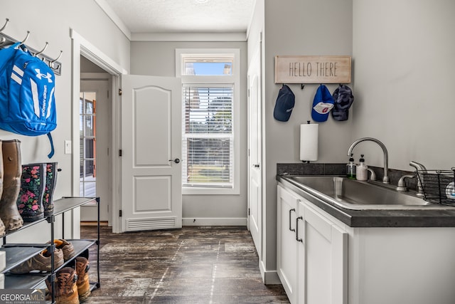 kitchen with a textured ceiling, dark hardwood / wood-style flooring, sink, and white cabinets