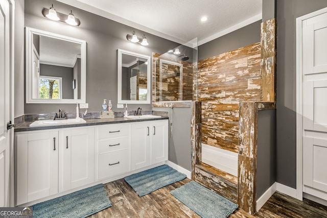 bathroom featuring a shower, hardwood / wood-style flooring, a textured ceiling, and crown molding