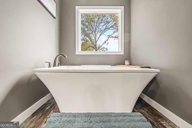 bathroom with wood-type flooring and a bathtub