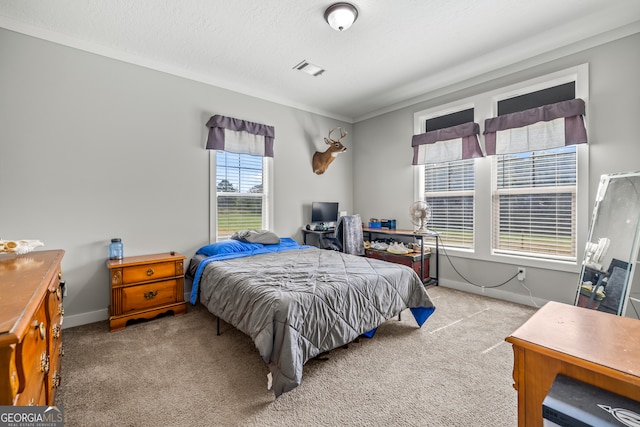 carpeted bedroom featuring ornamental molding and a textured ceiling