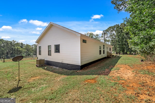 view of home's exterior featuring central AC unit and a lawn