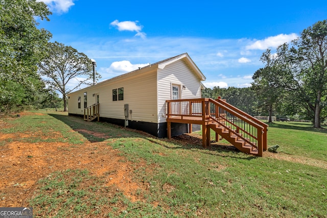 view of side of property featuring a yard and a wooden deck