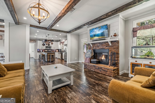 living room featuring dark hardwood / wood-style flooring, a fireplace, a notable chandelier, and beam ceiling