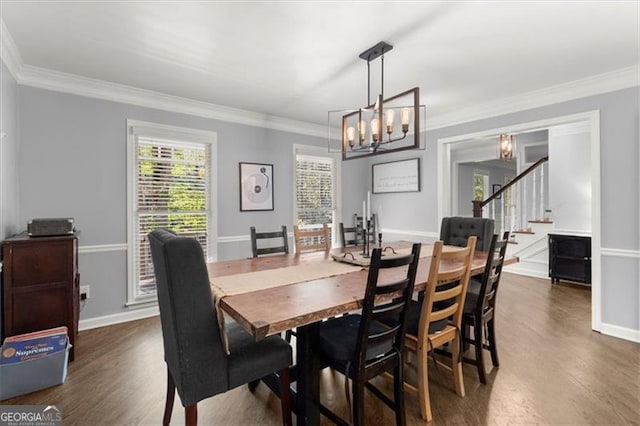 dining area featuring dark hardwood / wood-style floors, crown molding, and a notable chandelier