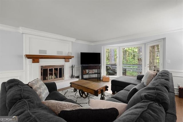 living room with wood-type flooring and ornamental molding