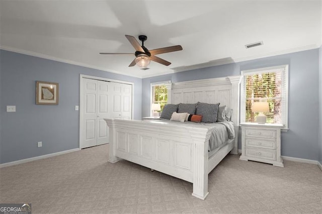 bedroom featuring a closet, light carpet, ceiling fan, and crown molding