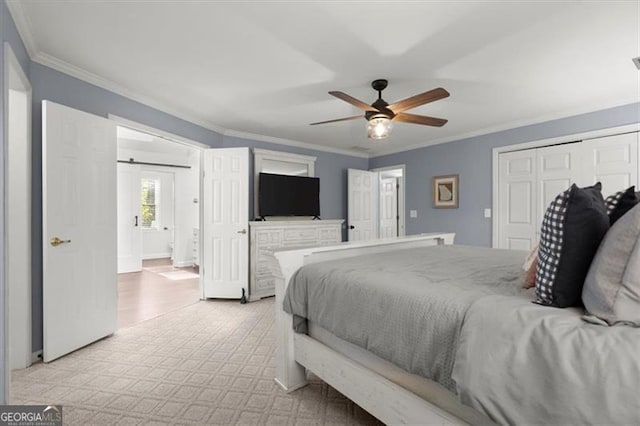 bedroom with a barn door, ceiling fan, a closet, and crown molding