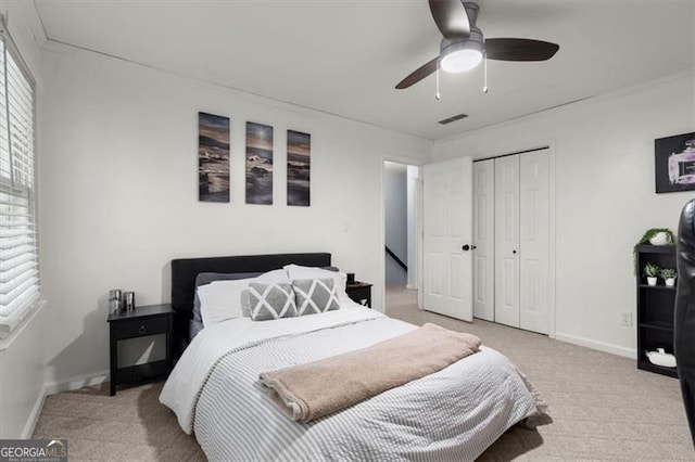 carpeted bedroom with ceiling fan and a closet