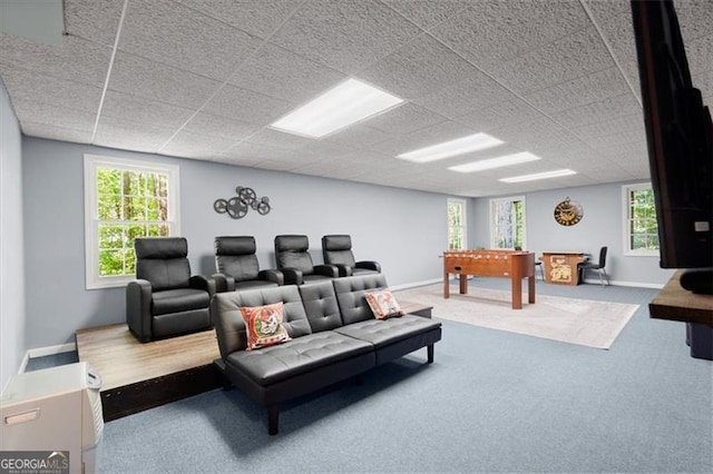 living room with a paneled ceiling, a wealth of natural light, and carpet