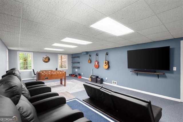 carpeted living room with a drop ceiling