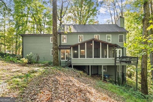 rear view of property featuring a sunroom