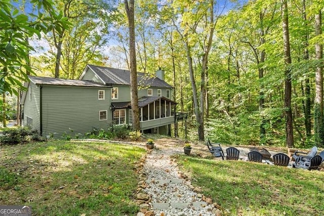 back of house with a sunroom and a yard