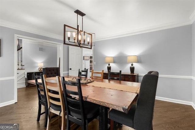 dining space featuring dark hardwood / wood-style floors, crown molding, and an inviting chandelier