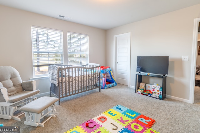 bedroom with a nursery area and light colored carpet