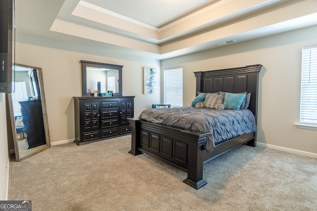 bedroom featuring light carpet, crown molding, and a raised ceiling