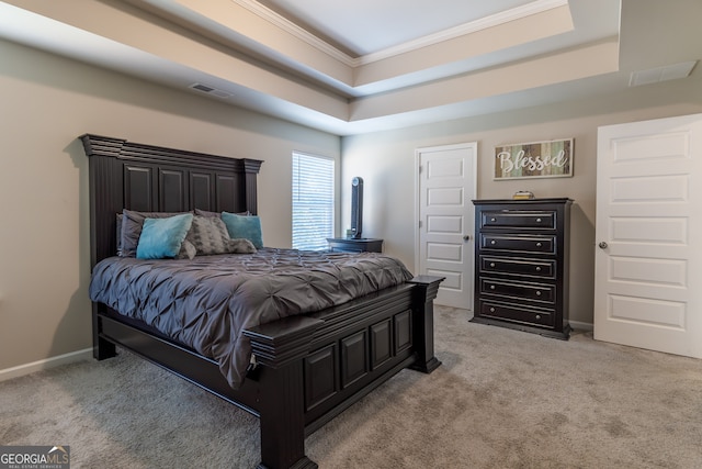 bedroom with crown molding, light colored carpet, and a raised ceiling