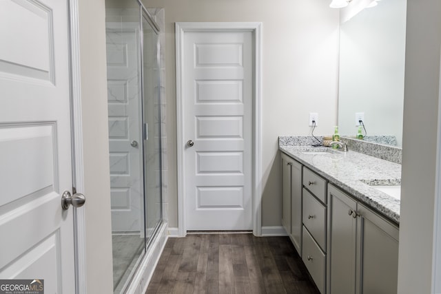 bathroom featuring vanity, hardwood / wood-style flooring, and a shower with shower door