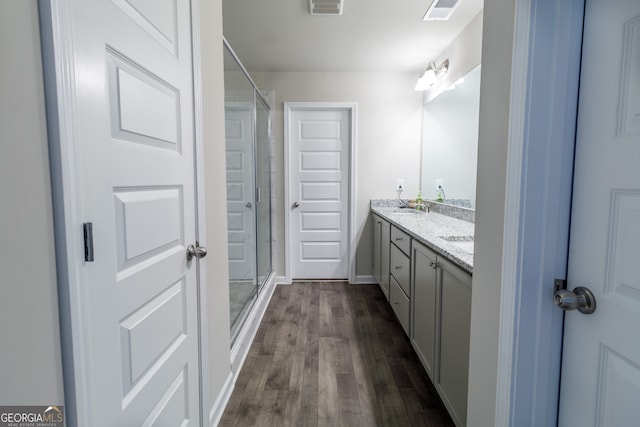 bathroom with a shower with door, vanity, and hardwood / wood-style floors