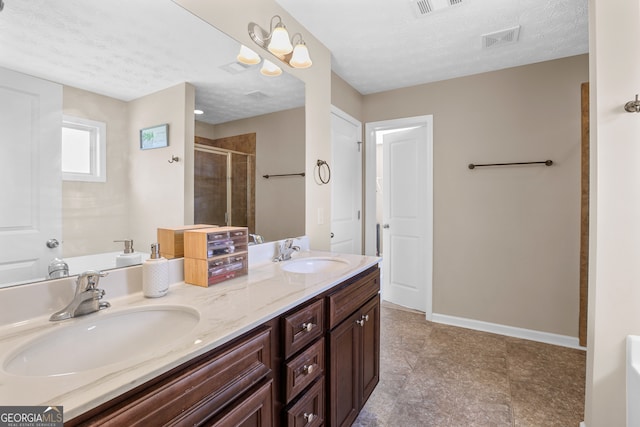 bathroom featuring vanity, a textured ceiling, and a shower with door