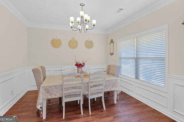 dining area featuring crown molding, an inviting chandelier, and dark hardwood / wood-style floors