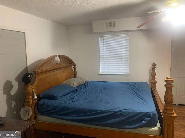 bedroom featuring a textured ceiling, hardwood / wood-style flooring, and ceiling fan