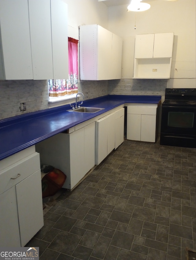 kitchen featuring decorative backsplash, white cabinetry, sink, and electric range