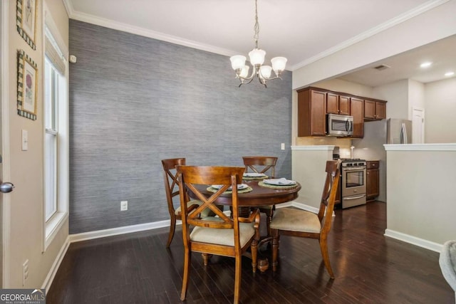 dining room featuring dark hardwood / wood-style flooring, ornamental molding, and a chandelier