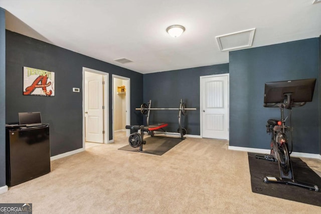 workout room featuring light carpet