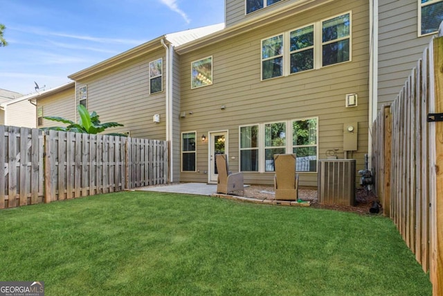 rear view of property with a lawn, a patio, and central AC