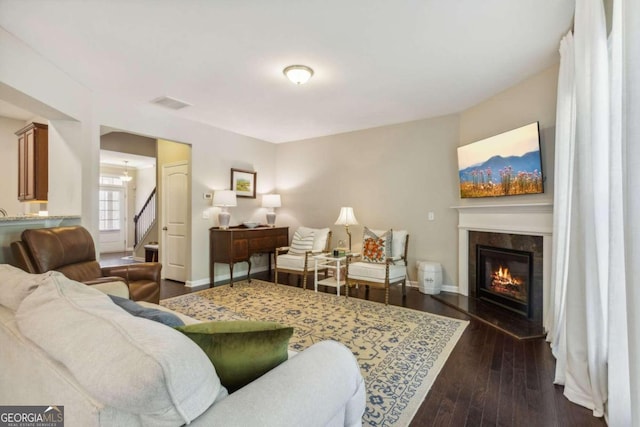 living room with dark hardwood / wood-style floors and a high end fireplace