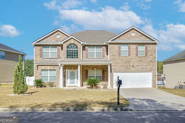 view of front of house with central AC, a front yard, and a garage