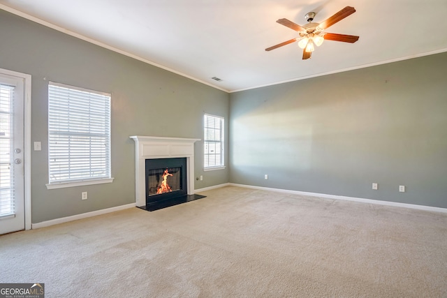 unfurnished living room featuring ornamental molding, light carpet, and ceiling fan