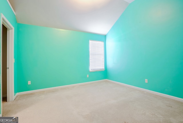 empty room with light carpet and vaulted ceiling