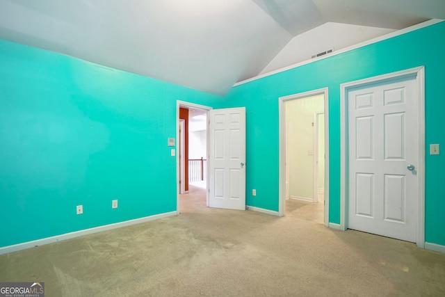 unfurnished bedroom with light carpet and lofted ceiling