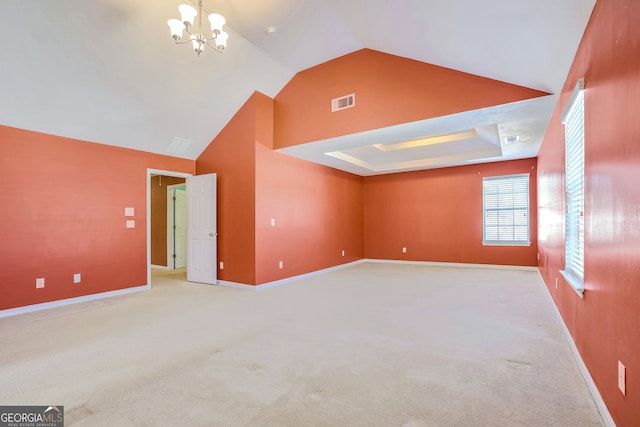 unfurnished room featuring lofted ceiling, a chandelier, light carpet, and a raised ceiling