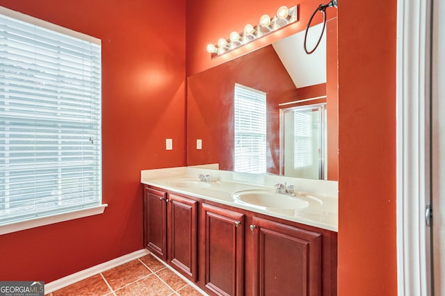 bathroom featuring vanity, tile patterned floors, and vaulted ceiling