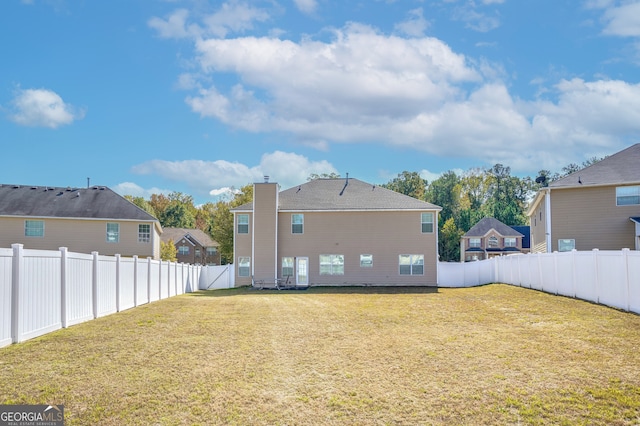 rear view of house featuring a yard