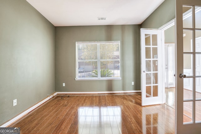 spare room featuring light hardwood / wood-style flooring and french doors