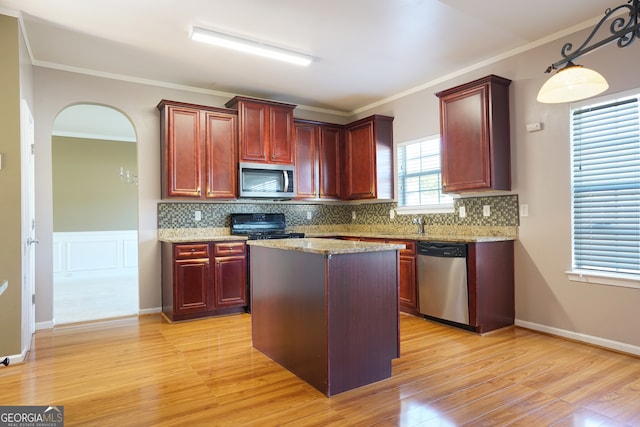 kitchen with light hardwood / wood-style floors, tasteful backsplash, appliances with stainless steel finishes, and light stone counters