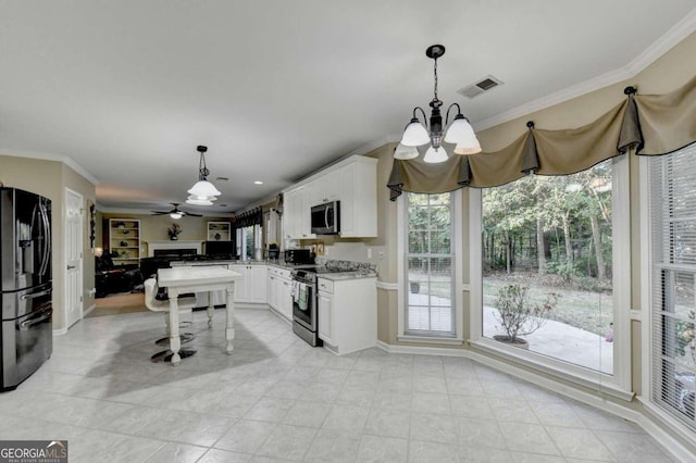 kitchen with white cabinetry, a healthy amount of sunlight, appliances with stainless steel finishes, and decorative light fixtures