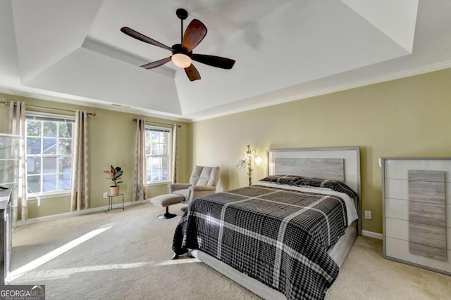 carpeted bedroom featuring ceiling fan, crown molding, and a tray ceiling