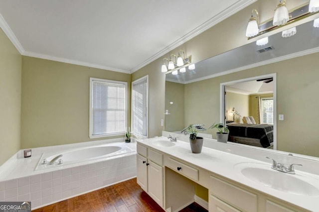 bathroom featuring vanity, crown molding, hardwood / wood-style floors, and tiled tub