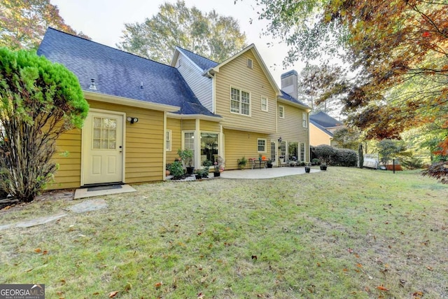 rear view of property featuring a patio area and a lawn