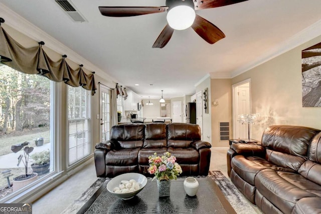 living room featuring ornamental molding, carpet floors, and ceiling fan