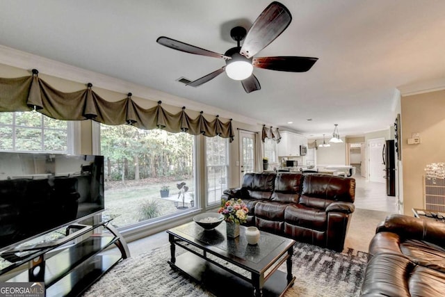 carpeted living room with crown molding and ceiling fan