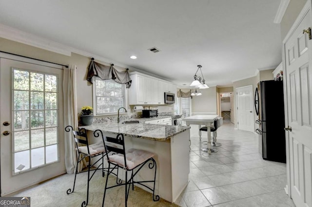 kitchen featuring sink, kitchen peninsula, a kitchen breakfast bar, stainless steel appliances, and pendant lighting