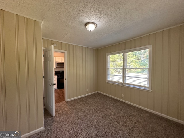 unfurnished room featuring dark colored carpet and a textured ceiling