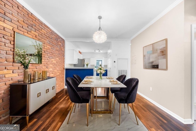 dining space with brick wall, dark wood-type flooring, crown molding, and an inviting chandelier